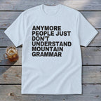 White t-shirt with black text reading "anymore people just don't understand mountain grammar".