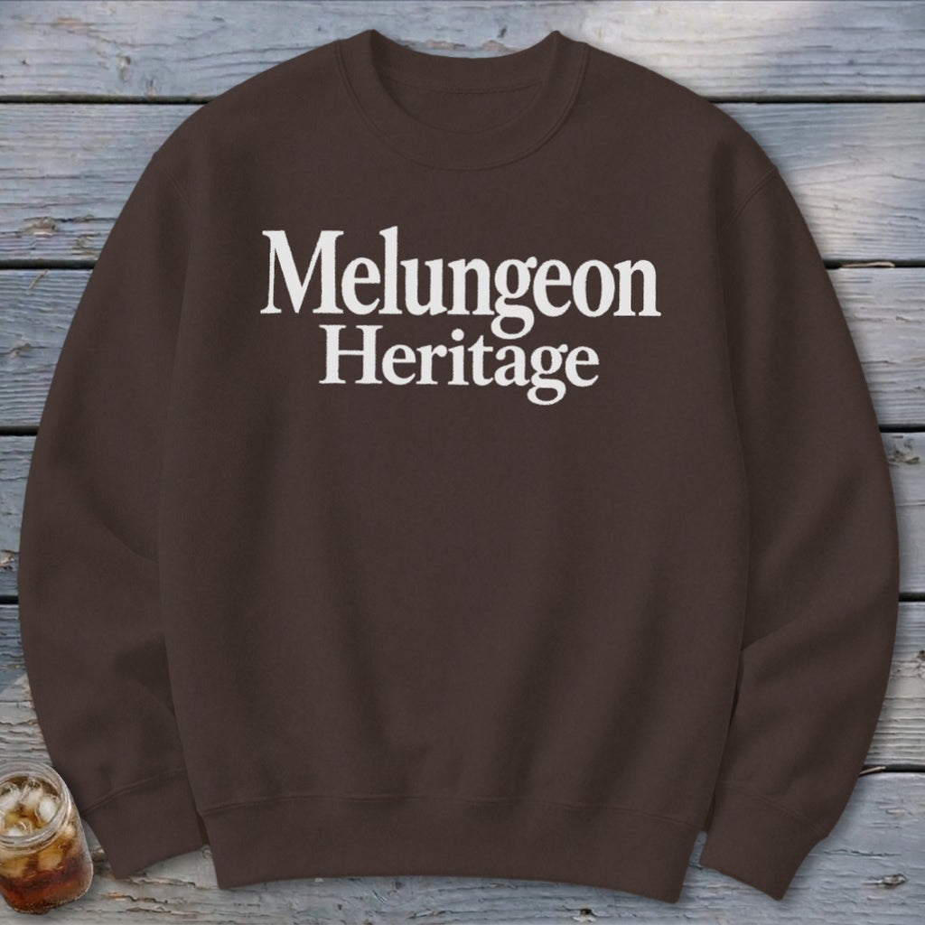 A brown crewneck sweatshirt with the white text Melungeon Heritage centered on the chest.