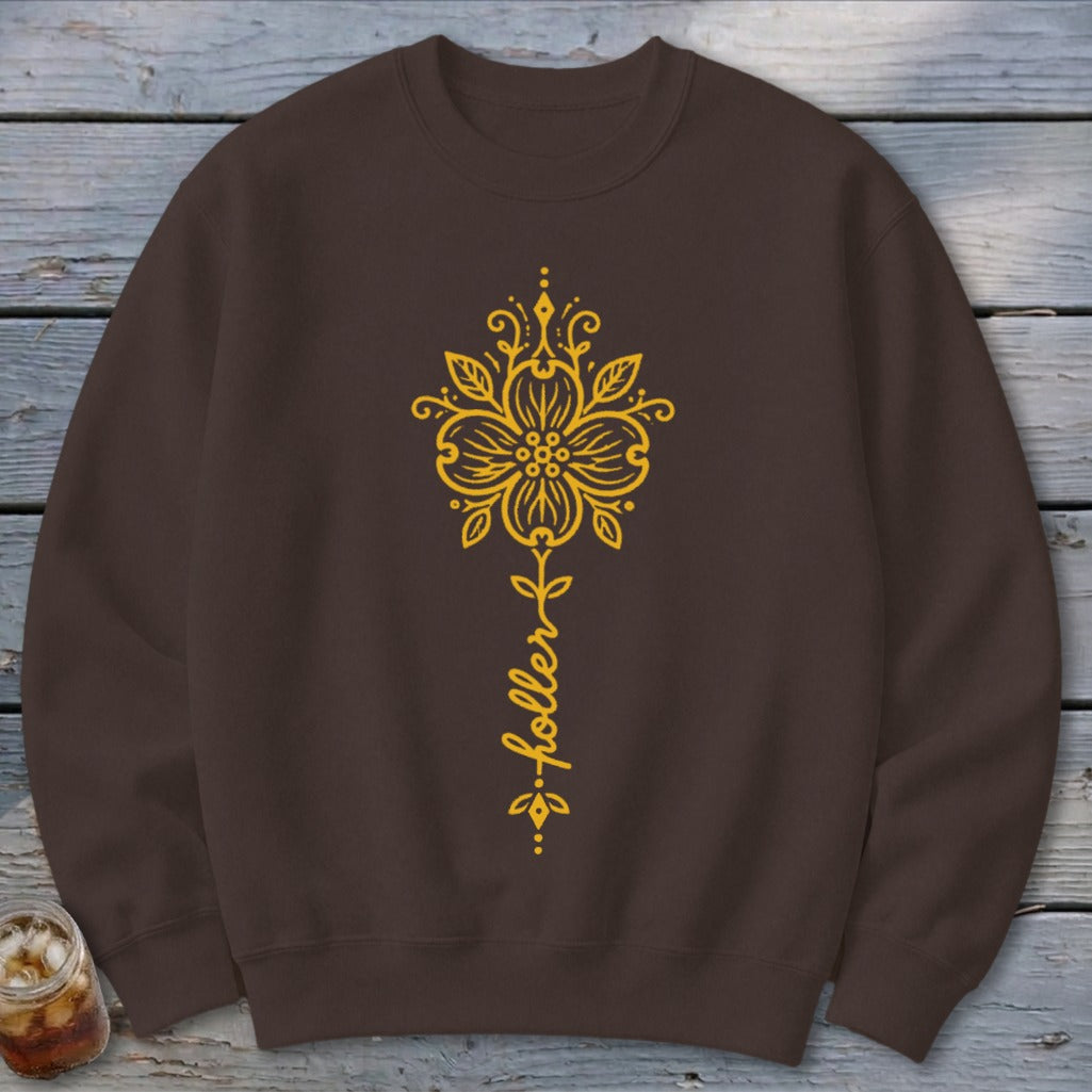 Brown sweatshirt with yellow floral design and script text "holler".