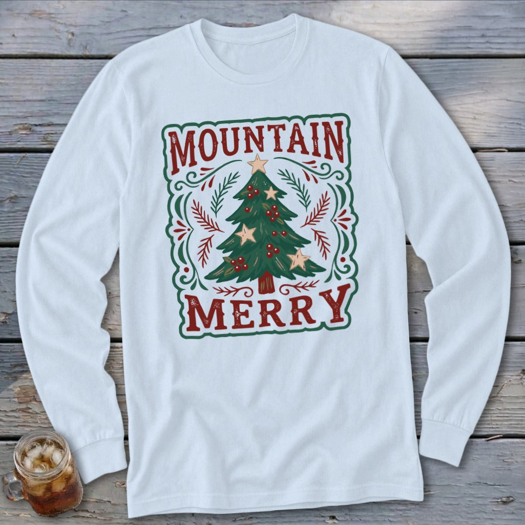 A white long-sleeved t-shirt featuring a green and red Christmas graphic with the text Mountain Merry.