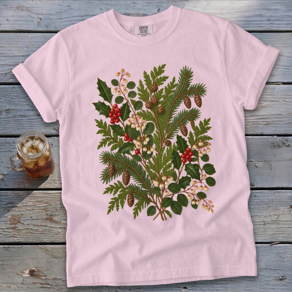 Pink t-shirt with botanical illustration of holly, pine branches, and berries.