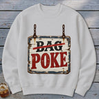A white crewneck sweatshirt featuring a graphic of a rustic, weathered wooden sign with the text BAG POKE.