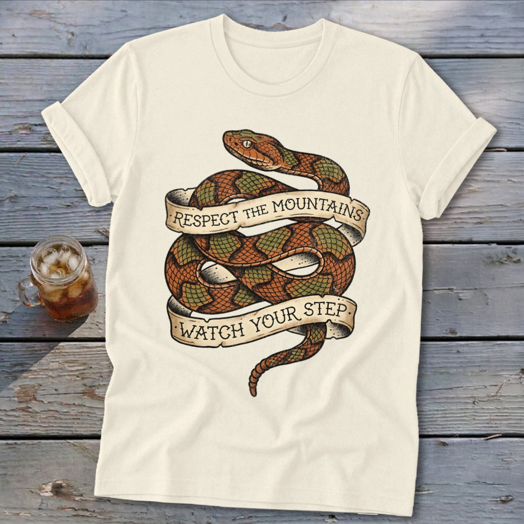 Cream t-shirt with coiled snake graphic reading "Respect the Mountains, Watch Your Step".