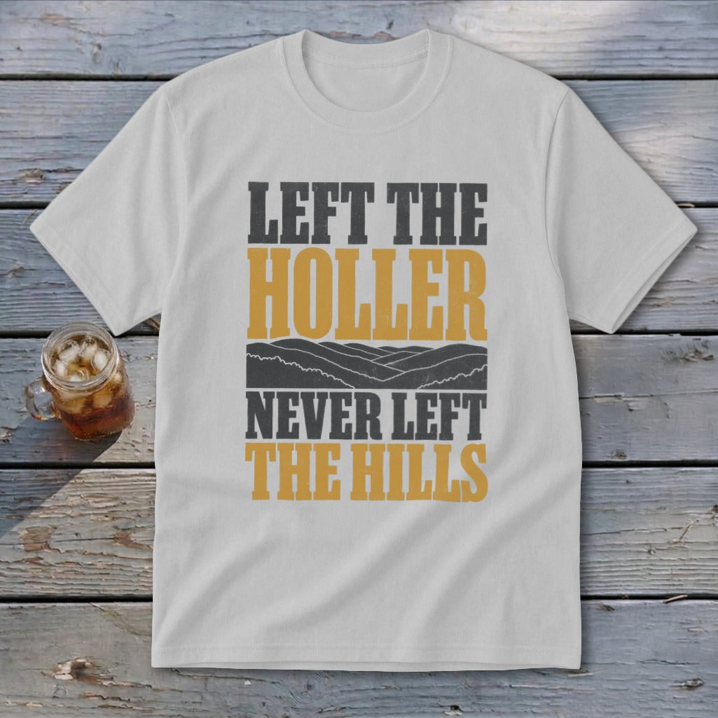 White t-shirt with text "Left the Holler Never Left the Hills" and mountain graphics.