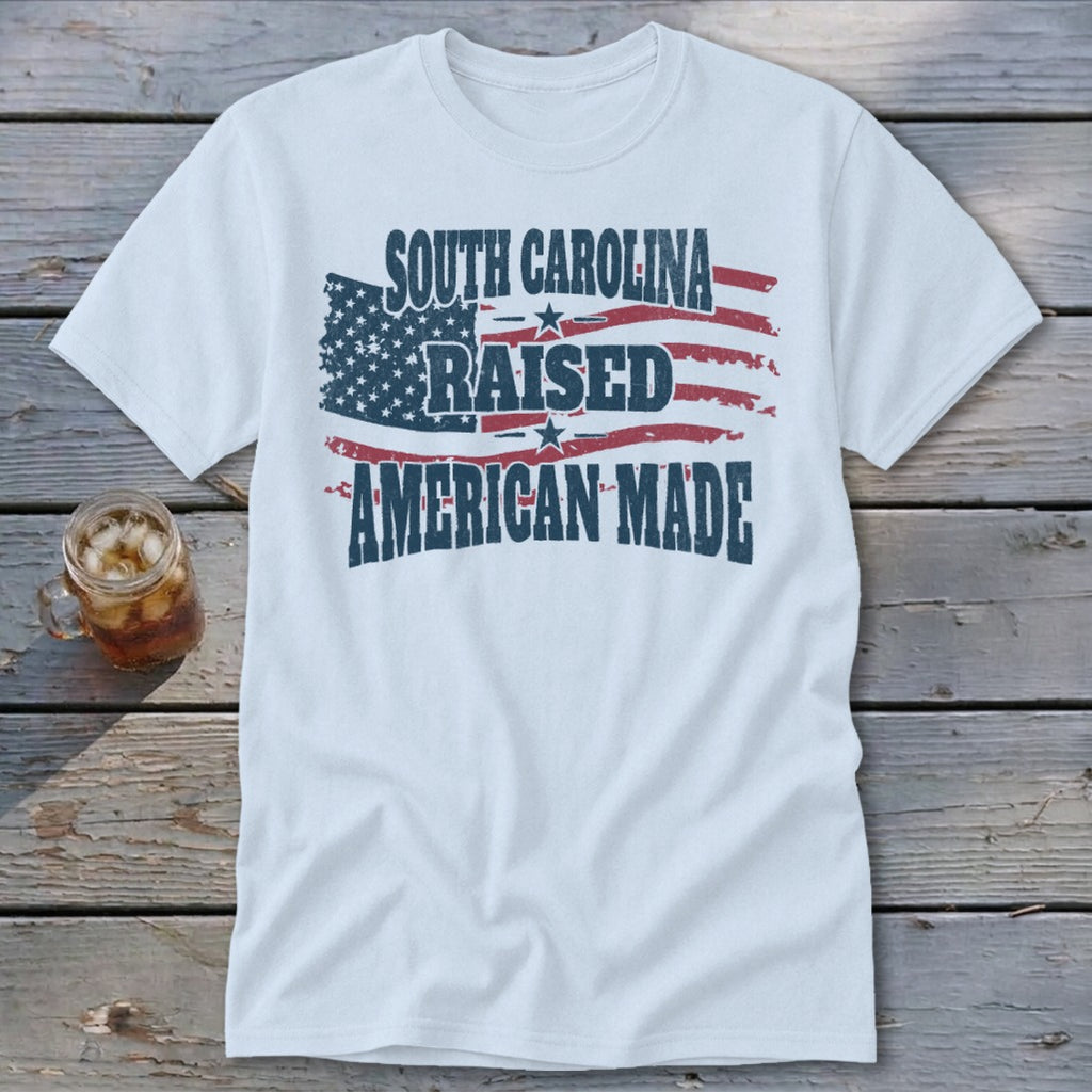 White t-shirt with distressed American flag design and text: South Carolina Raised American Made.