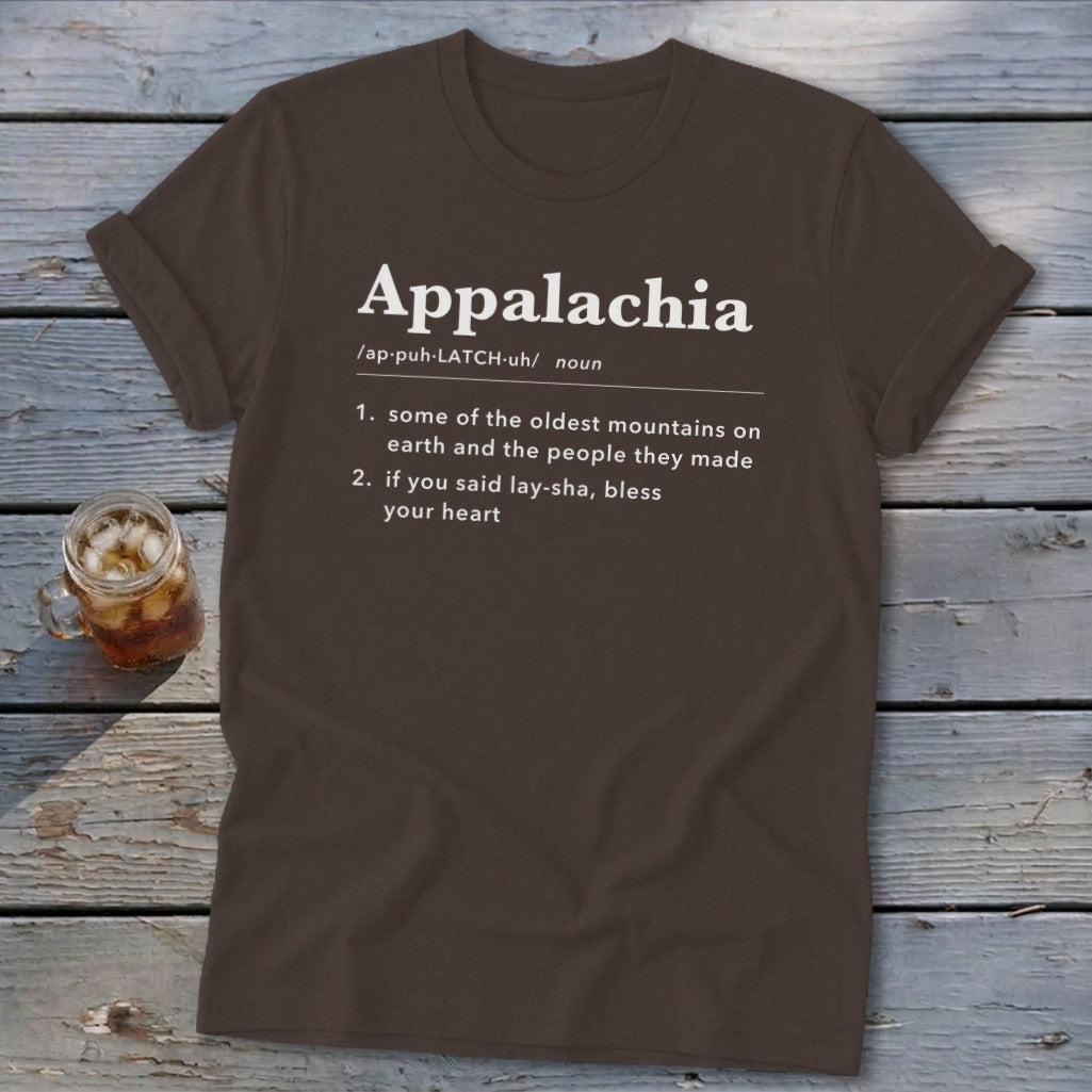 Brown t-shirt featuring dictionary-style text defining Appalachia, laid flat on a rustic wooden surface.