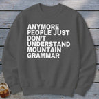 Dark gray sweatshirt with white text "Anymore people just don't understand mountain grammar."