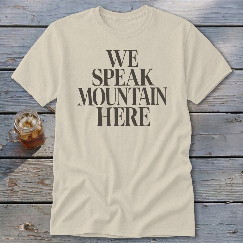 Cream t-shirt with dark gray text reading "WE SPEAK MOUNTAIN HERE."