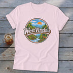Pink t-shirt with "West Virginia" graphic featuring a river, mountains, trees, and a deer.