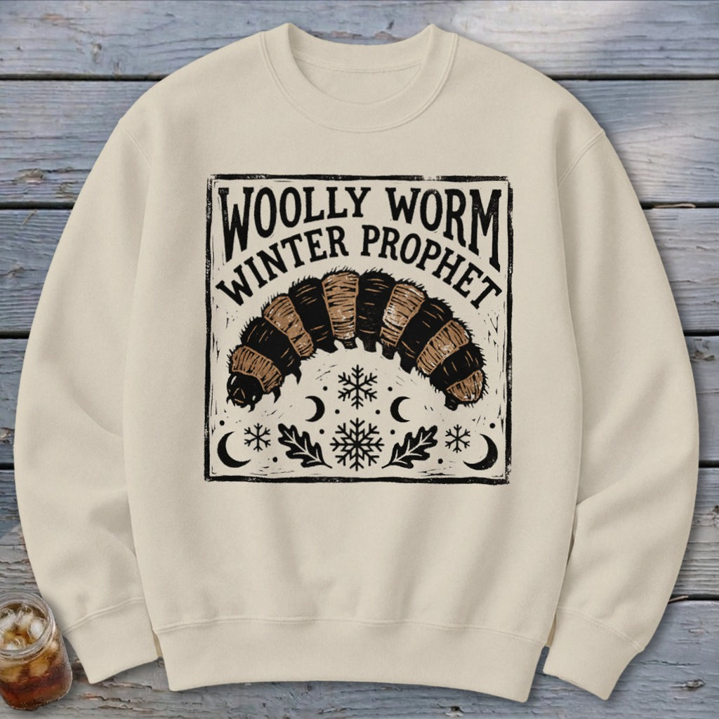 Beige crewneck sweatshirt featuring a graphic of a woolly worm caterpillar with text reading Woolly Worm Winter Prophet.