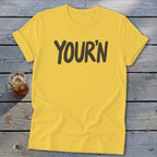 Yellow t-shirt with "YOUR'N" printed in dark letters.