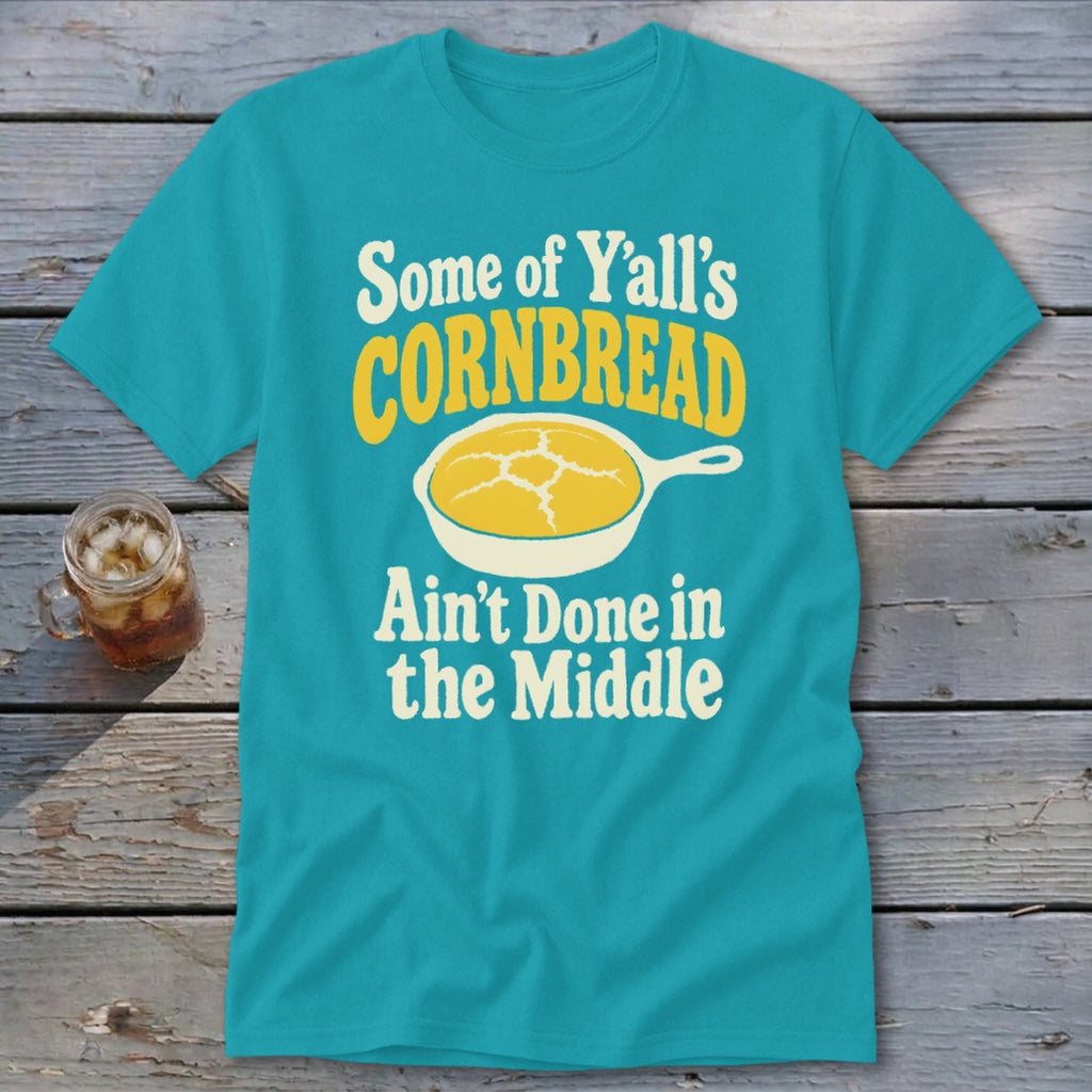 A turquoise t-shirt with the graphic text "Some of Y'all's Cornbread Ain't Done in the Middle."