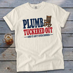 Cream t-shirt with "PLUMBER TUCKERED OUT -AND IT AIN'T EVEN DINNER-" text and rocking chair.