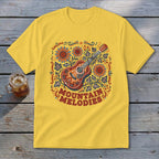 A yellow t-shirt features a colorful acoustic guitar graphic with sunflowers, foliage, and the text MOUNTAIN MELODIES.