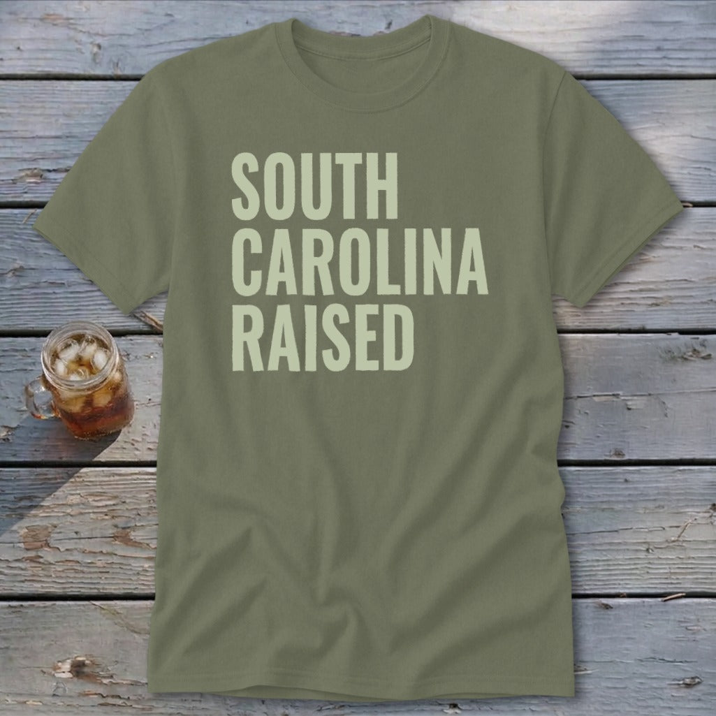 Olive green t-shirt with "SOUTH CAROLINA RAISED" text in light cream.