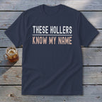 Navy t-shirt with white and peach text reading "THESE HOLLERS KNOW MY NAME".