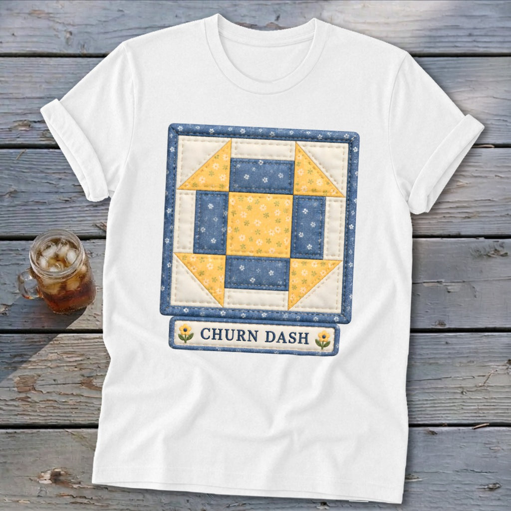 White t-shirt featuring a "Churn Dash" quilt block design with yellow and blue floral patterns.