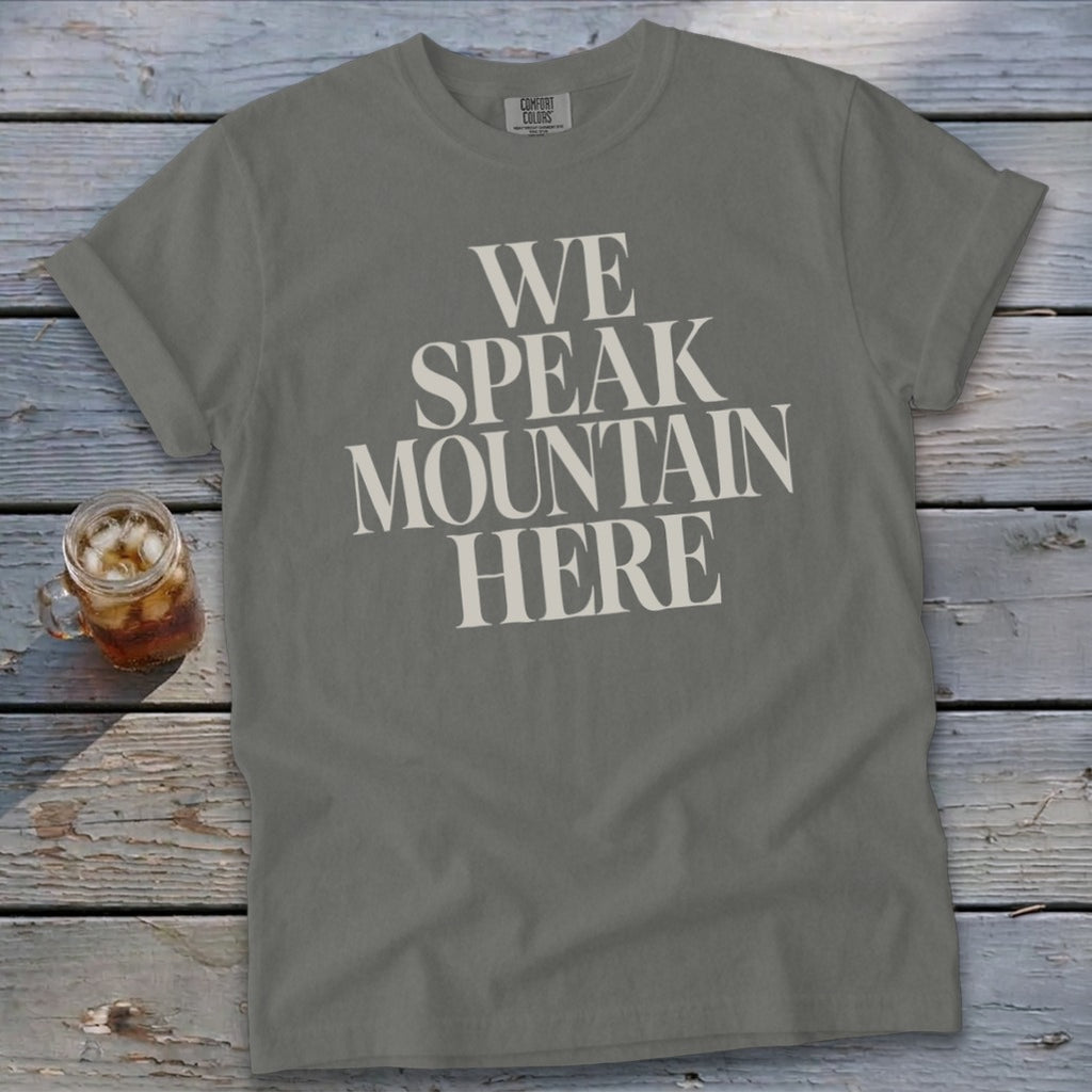 Gray t-shirt with "WE SPEAK MOUNTAIN HERE" text and a glass of iced tea.