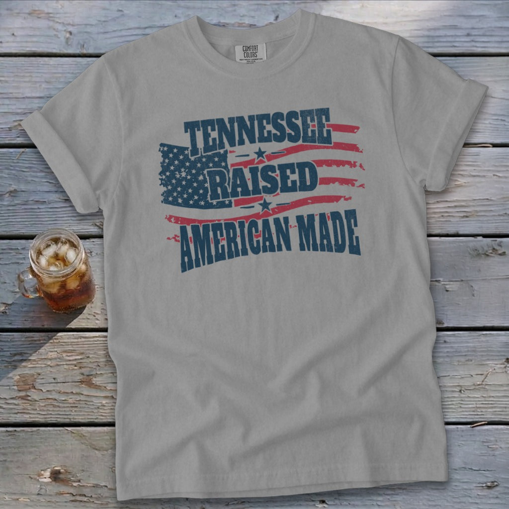 Gray t-shirt with "Tennessee Raised American Made" text and American flag graphic.