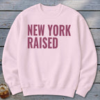 Pink crewneck sweatshirt with "NEW YORK RAISED" text in maroon.