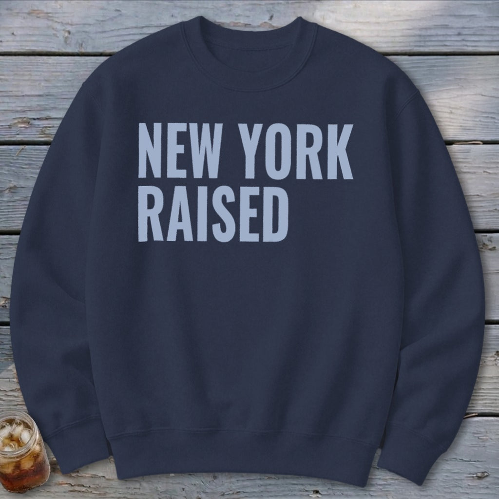 Navy sweatshirt with light blue text reading "NEW YORK RAISED"