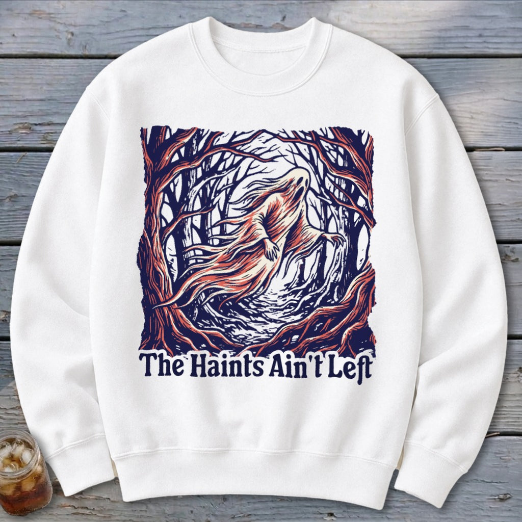 White sweatshirt with ghost in spooky forest graphic and text "The Haints Ain't Left".