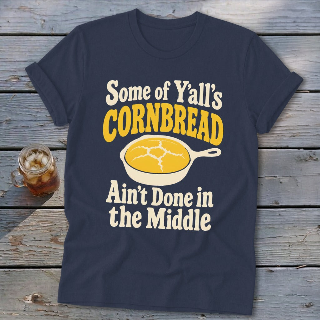 Navy blue t-shirt featuring the text "Some of Y'all's Cornbread Ain't Done in the Middle" and a skillet graphic.