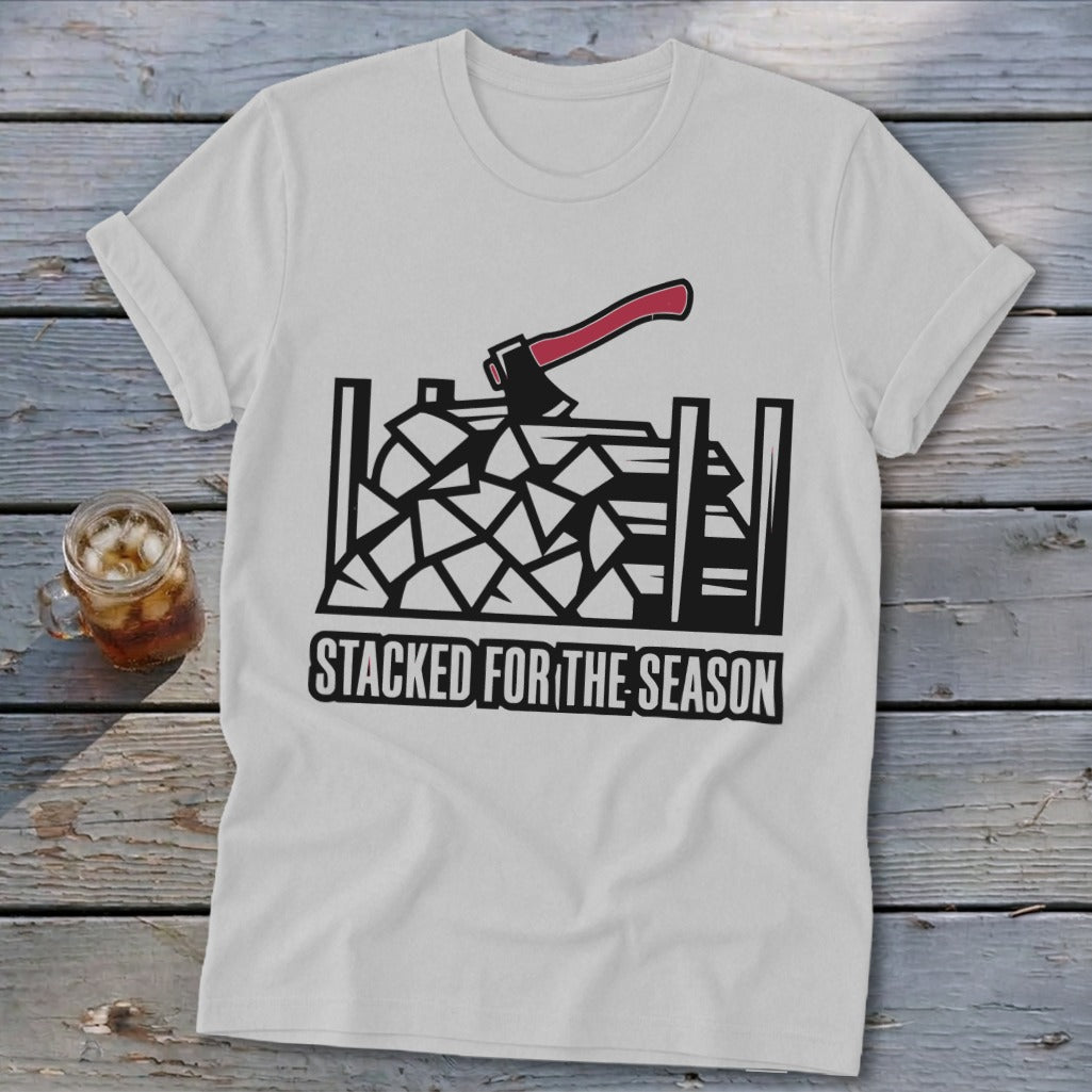 White t-shirt with black graphic of stacked firewood and an axe, text reads "STACKED FOR THE SEASON".