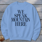Light blue crewneck sweatshirt with "WE SPEAK MOUNTAIN HERE" text in dark blue.
