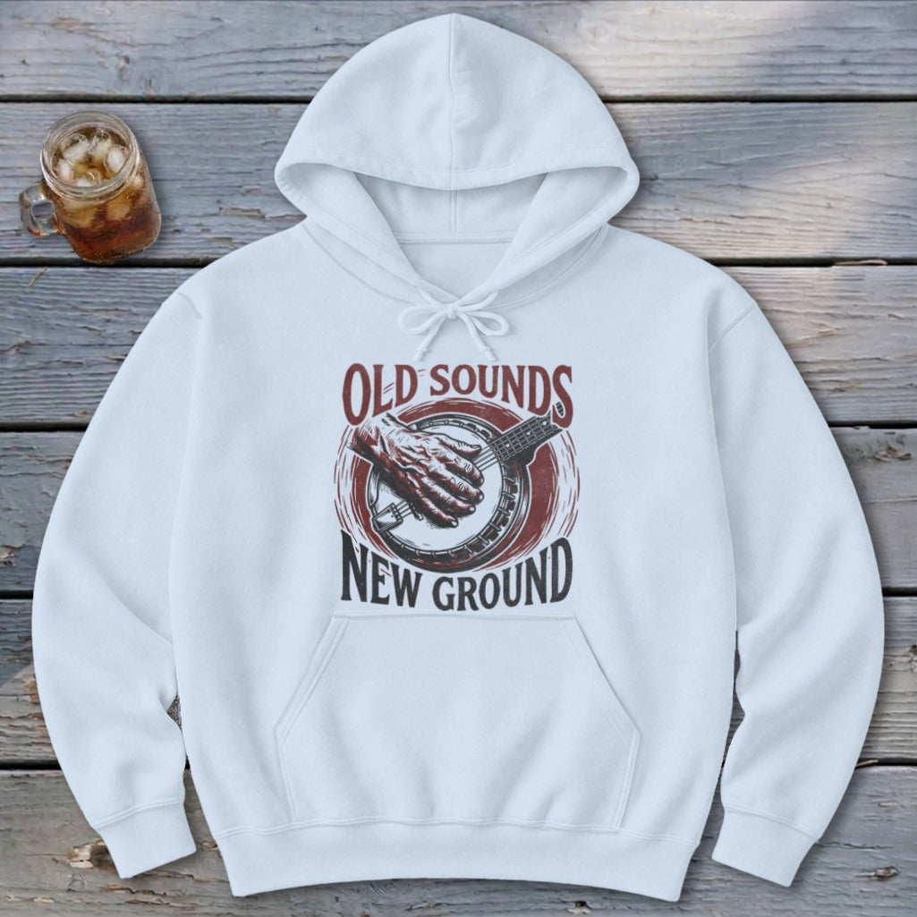 White hooded sweatshirt featuring a front graphic of a hand playing a banjo with text Old Sounds New Ground.