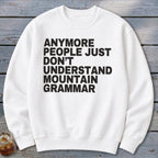 White sweatshirt with black text that reads "anymore people just don't understand mountain grammar."