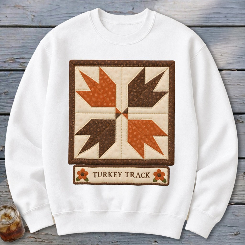 White sweatshirt with a quilt block design labeled "Turkey Track."