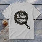 White t-shirt with "NO SUGAR IN THE CORNBREAD" graphic in a cast iron skillet.
