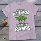 A light purple t-shirt featuring green text reading IF YOU SEE ME IN THE WOODS I'M HUNTIN RAMPS above an illustration of three ramps plants.