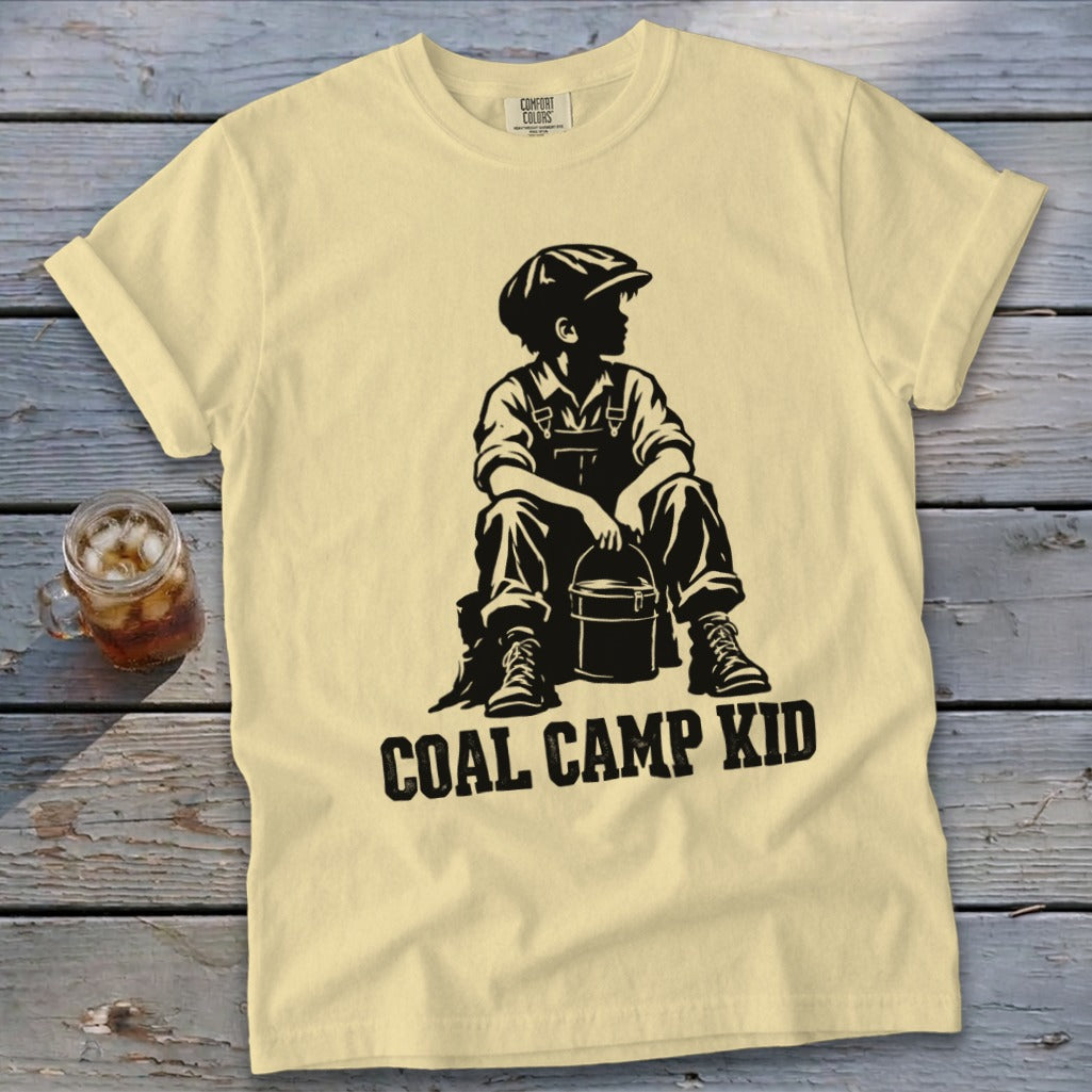Yellow t-shirt with black graphic of a boy in overalls and cap holding a bucket, text "COAL CAMP KID".