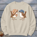 Two birds, one wearing a bonnet, the other a cap, facing each other.