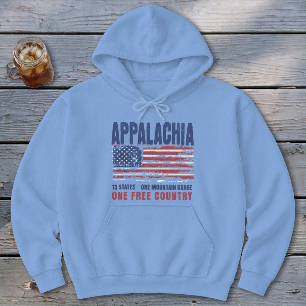 A light blue hoodie with Appalachia and an American flag graphic centered on a rustic wooden table.
