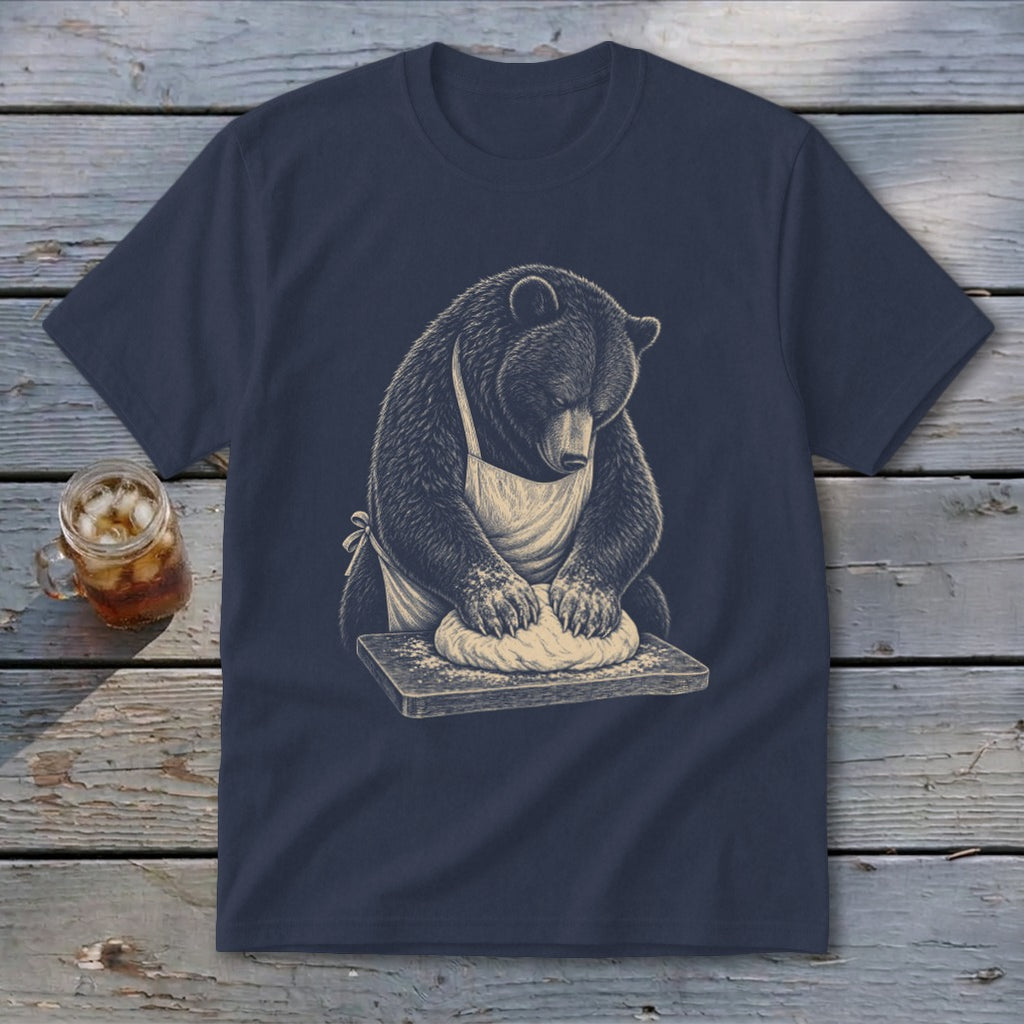 Bear wearing apron kneading dough on a wooden cutting board.