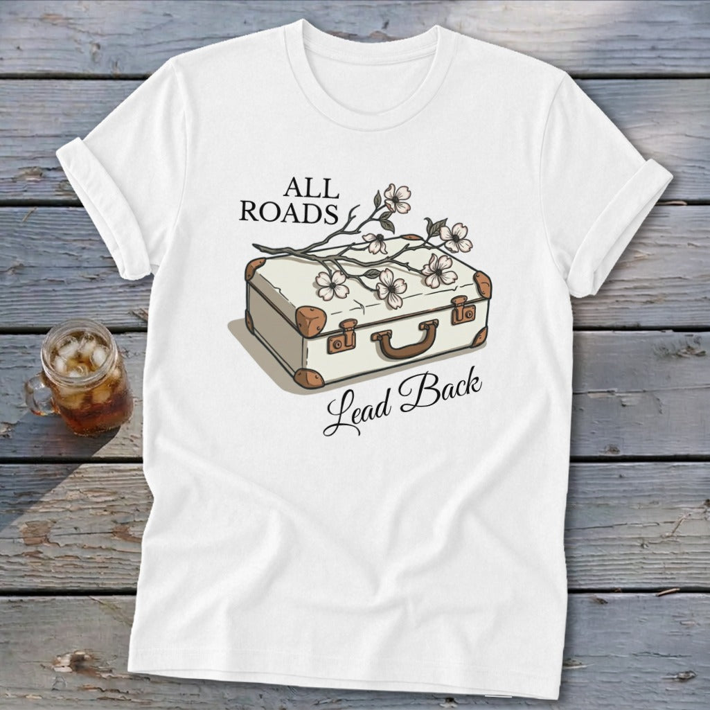 White t-shirt with a vintage suitcase, flowers, and the text "ALL ROADS Lead Back."