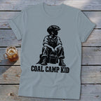 Light blue t-shirt with black graphic of a boy sitting with a bucket, text "COAL CAMP KID".