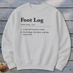 A light gray crewneck sweatshirt printed with black dictionary-style text defining the term Foot Log.