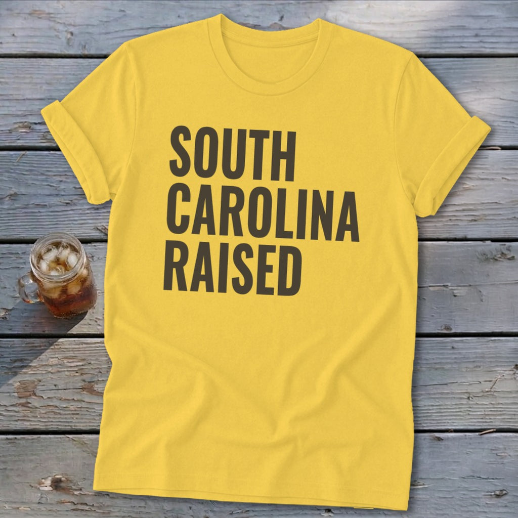 Yellow t-shirt with "SOUTH CAROLINA RAISED" text in dark gray.