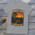 Light grey t-shirt with graphic "The Porch Light is Always On" over a cabin at sunset.