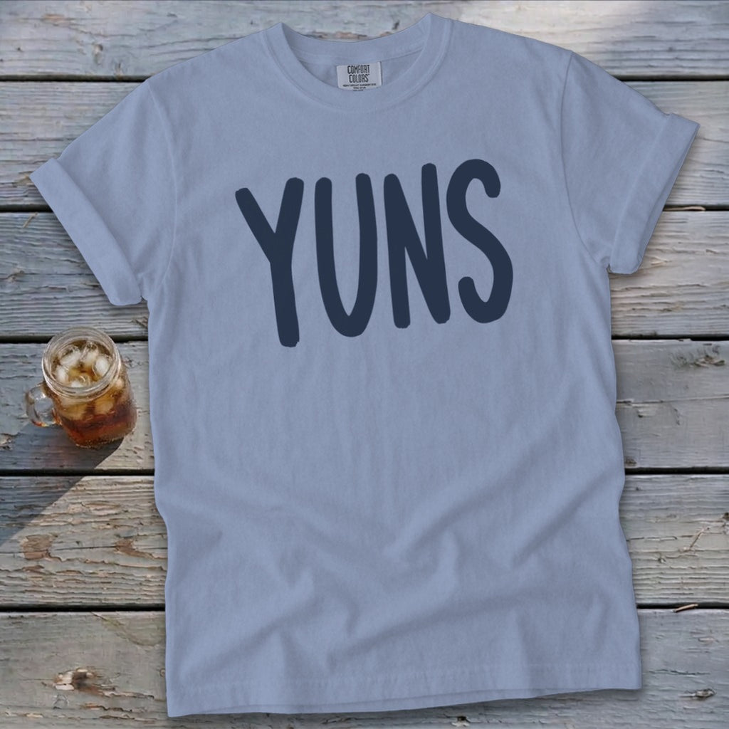 Light blue t-shirt with "YUNS" text in dark blue letters.
