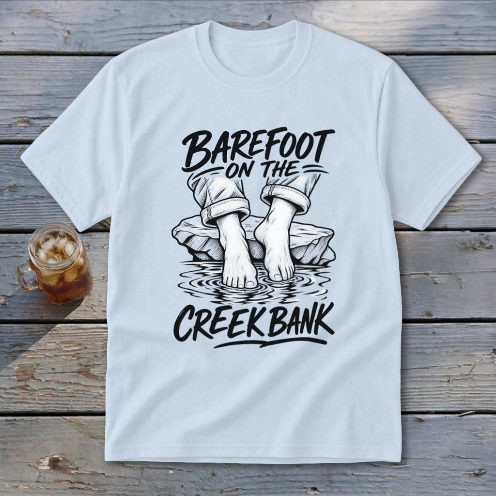 White t-shirt with "Barefoot on the Creek Bank" text and illustration of feet.