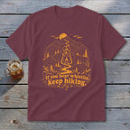 Maroon t-shirt with mountain, lantern, and text design: "If you hear whistlin', keep hiking."