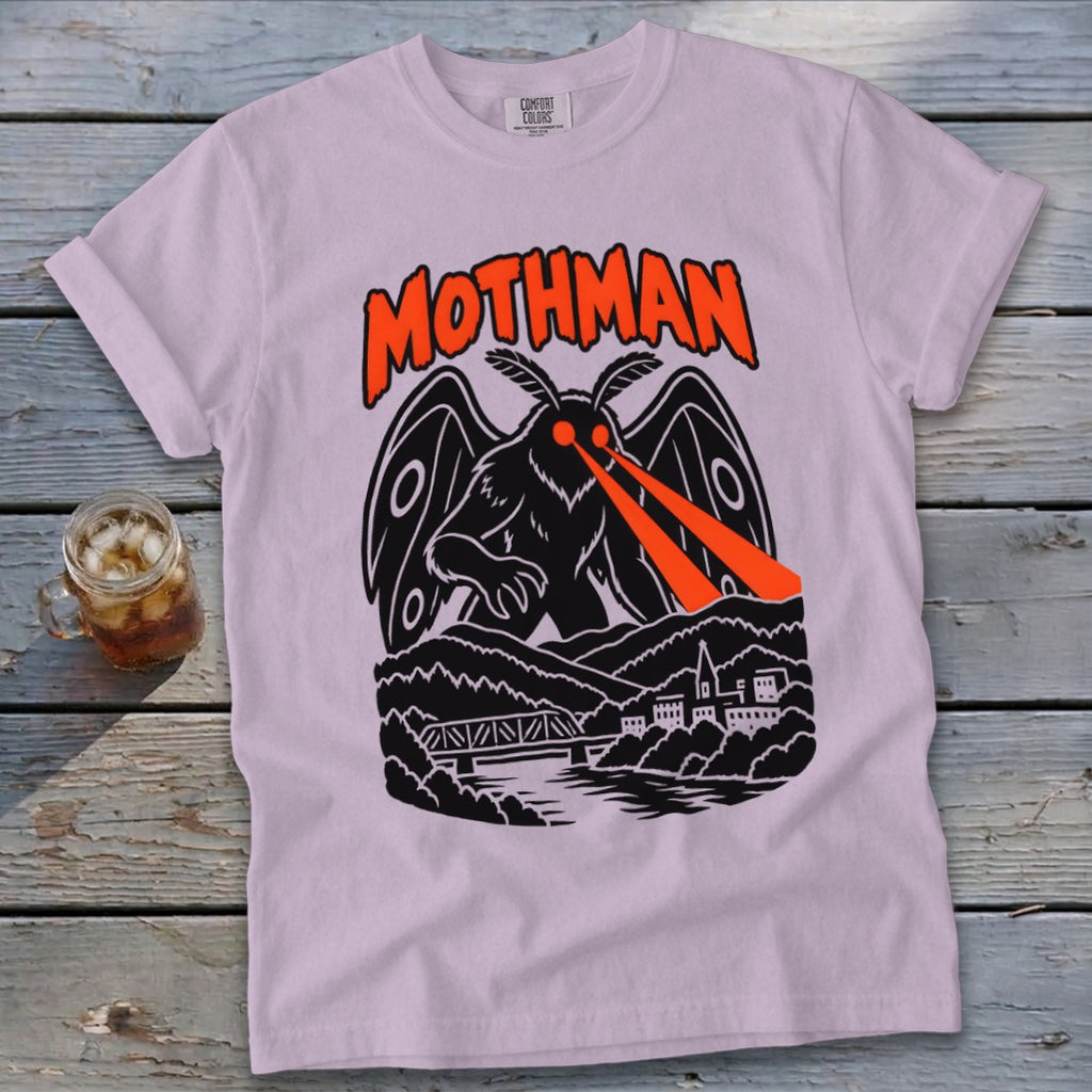 Pink t-shirt with Mothman graphic featuring red laser eyes, bridge, and town.