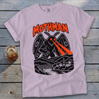 Pink t-shirt with Mothman graphic featuring red laser eyes, bridge, and town.