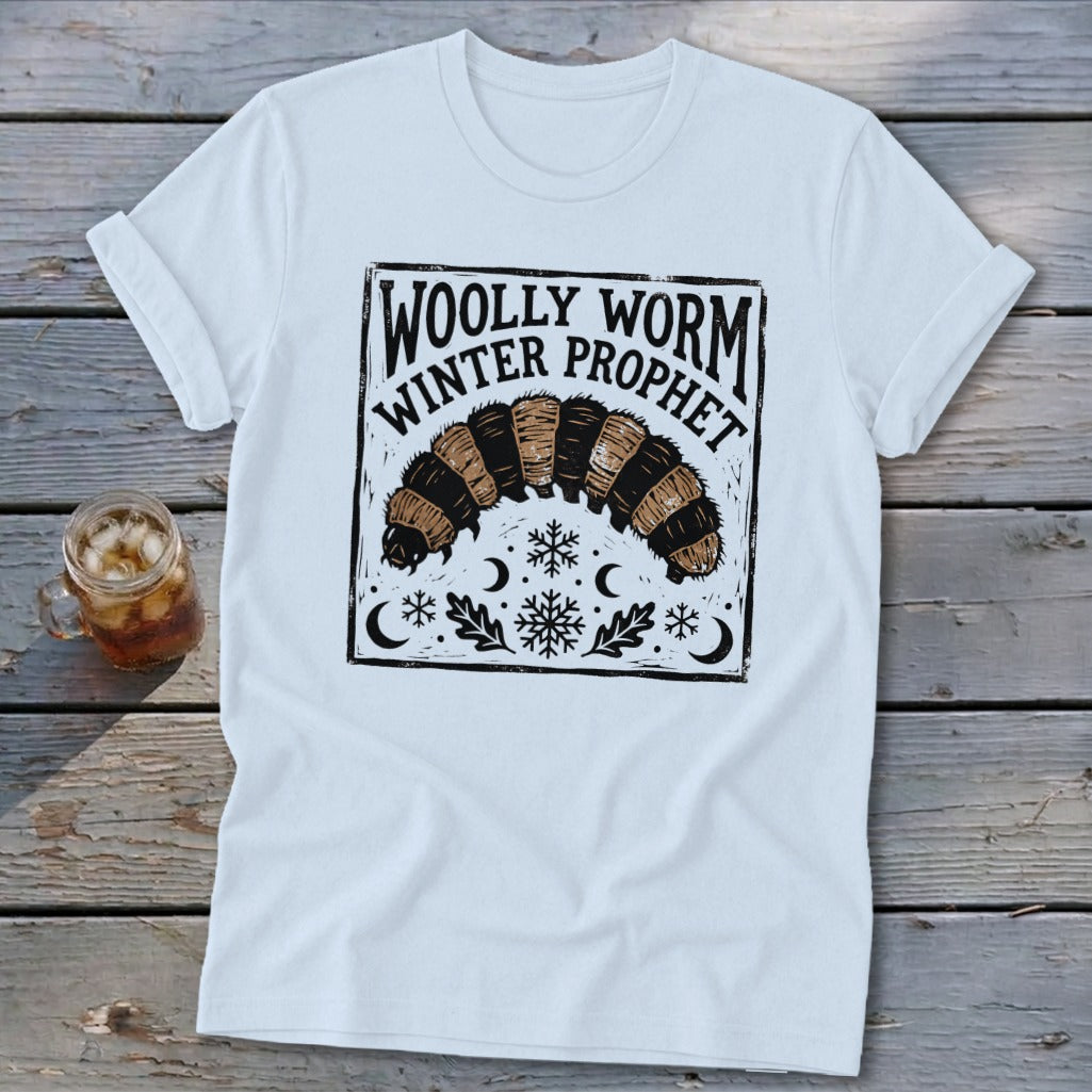 White t-shirt featuring a black graphic of a woolly worm with text reading Woolly Worm Winter Prophet.