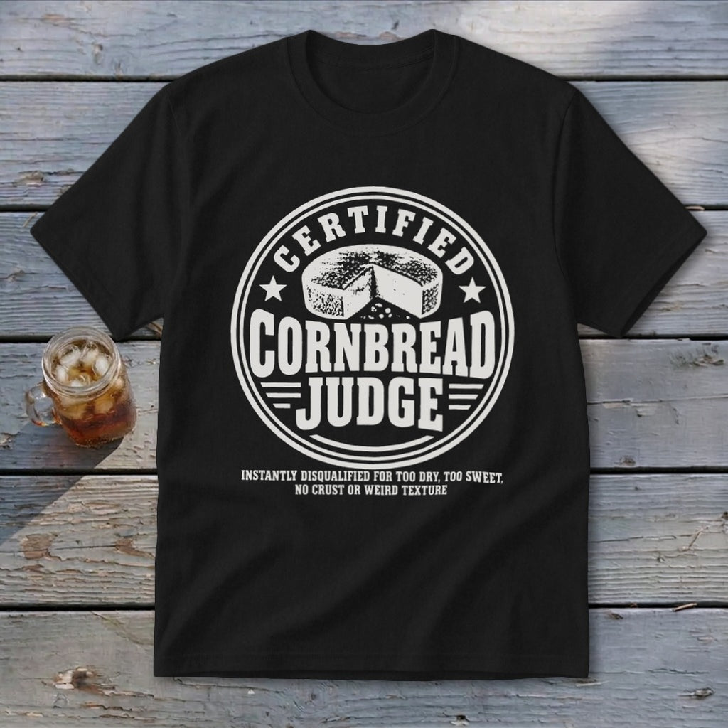 A black t-shirt features a circular white graphic with the text "Certified Cornbread Judge."